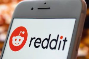 Photo of a smartphone with Reddit logo on the screen