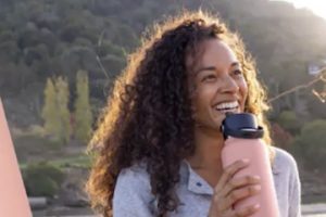Photo of a female holding a water bottle from Hydro Flask's website