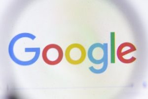 Google logo behind a magnifying glass
