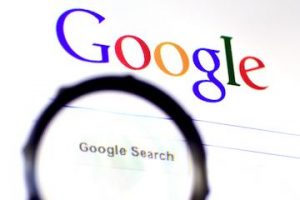Google logo next to a magnifying glass