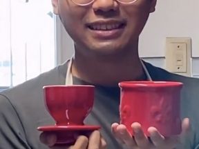 Image of a male holding two red cups for sale