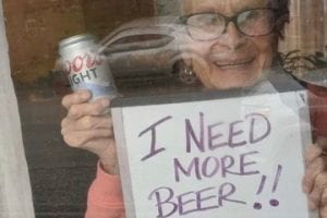 Photo of a 93-year-old lady holding "I Need a Beer" sign